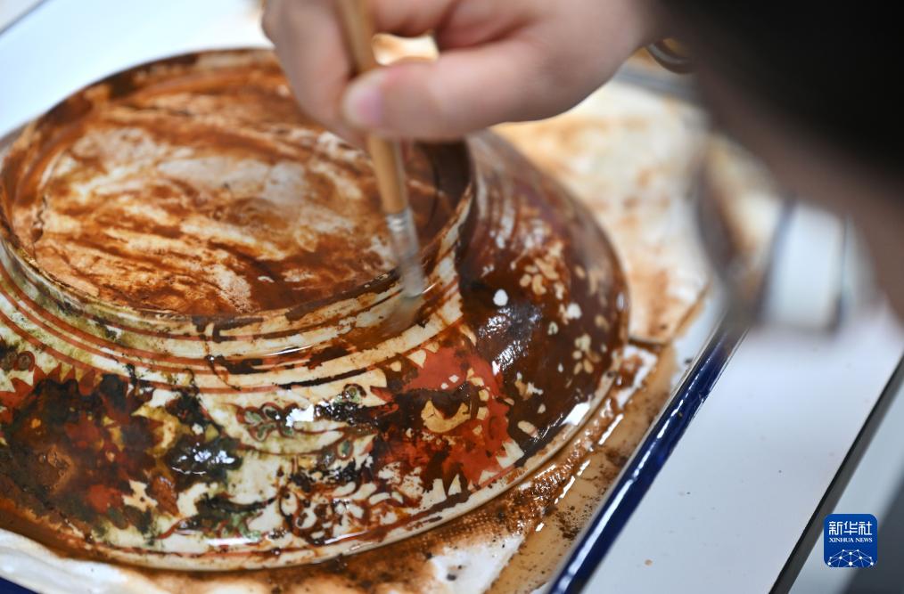 10月10日、文化財の表面をきれいにして修復を行う中國（海南）南海博物館の職員（撮影?郭程）。